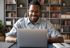 Man sitting on laptop happy.